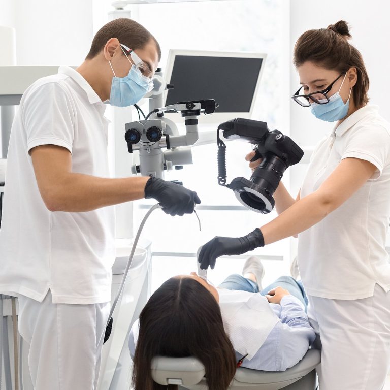 Snapping the result. Skillful dentists taking photo with professional camera of patient teeth